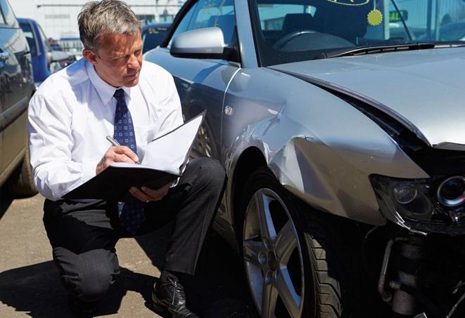 smiling couple receiving car insurance paperwork